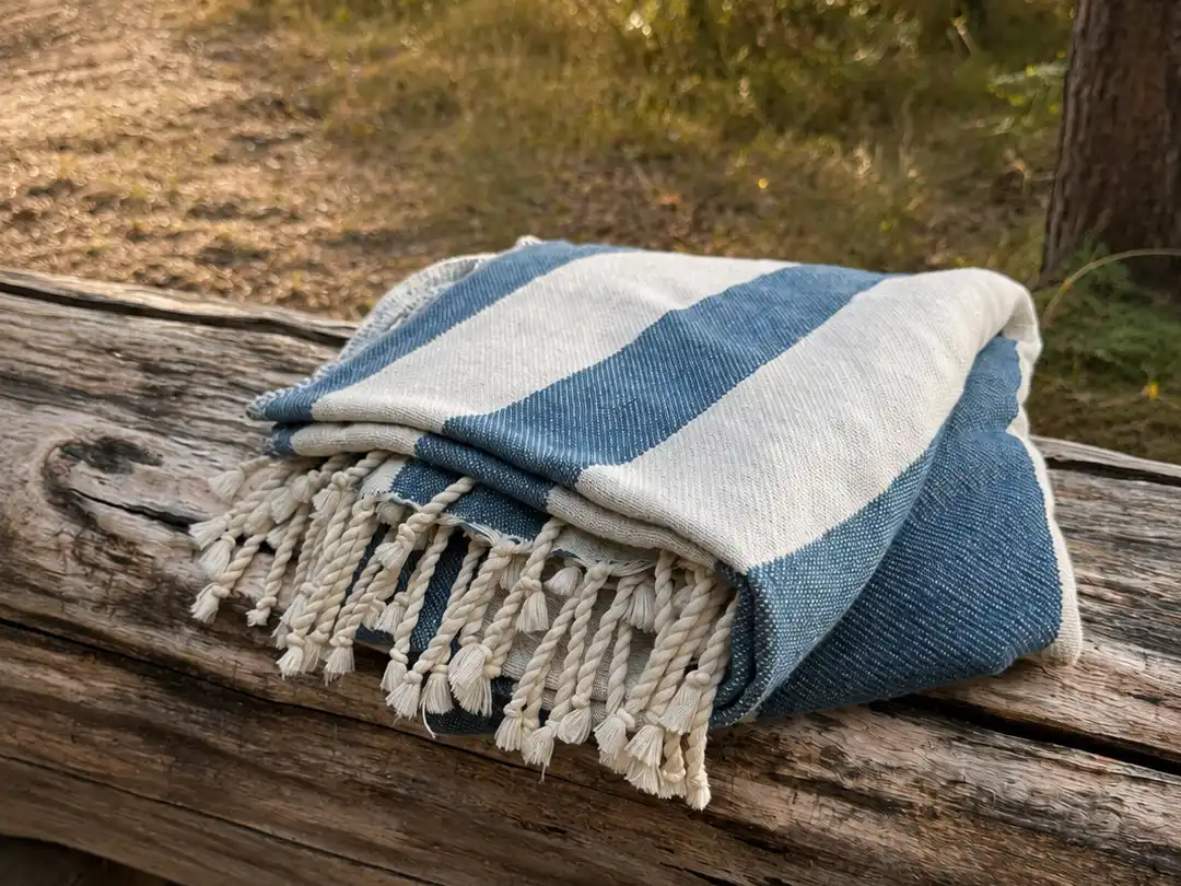 Hawuro fouta-pyyhe taiteltuna vanhan puupenkin päällä